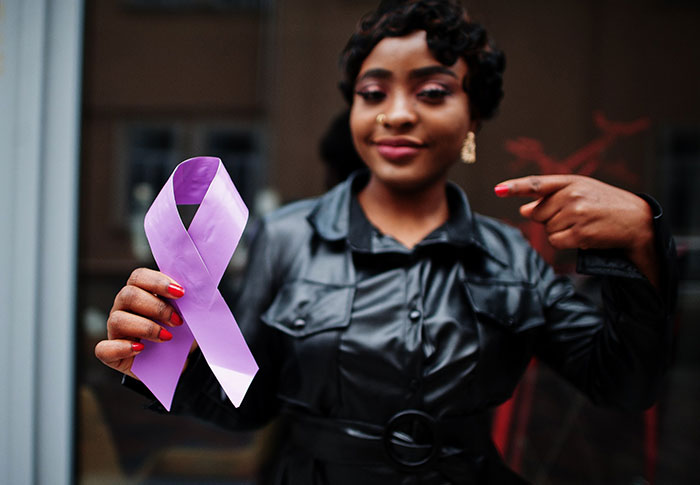 African American Woman hold purple ribbon